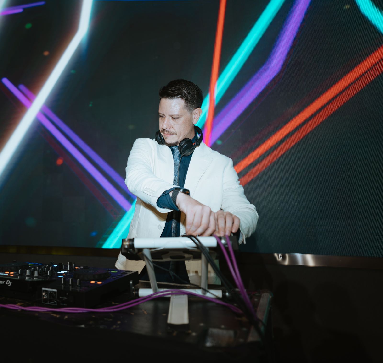Michele Mattotti at the decks, neon light geometry behind him